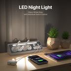 A desktop power strip with integrated LED night lighting shown on a wooden table, with a smartphone and earbud case charging under warm white light. Text at the top reads 'LED Night Light' and 'Warm White Glow with Individual Switch Control.